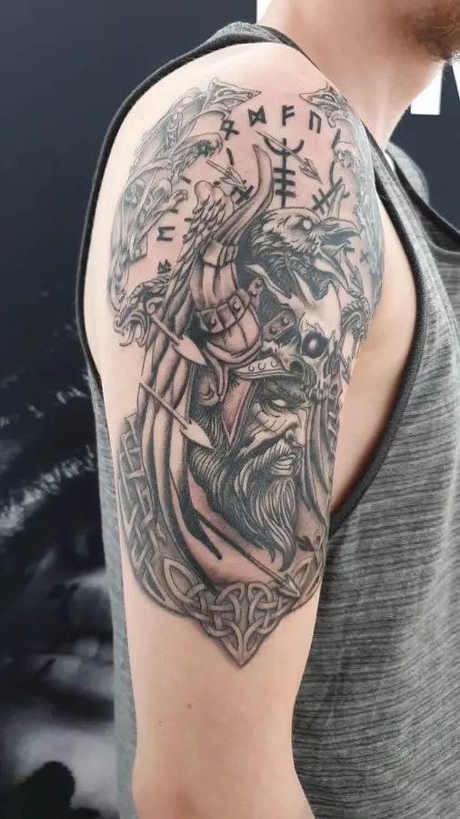 Nordisches Oberarm-Tattoo mit Wikinger, Rabe, Runen und Knotenmuster